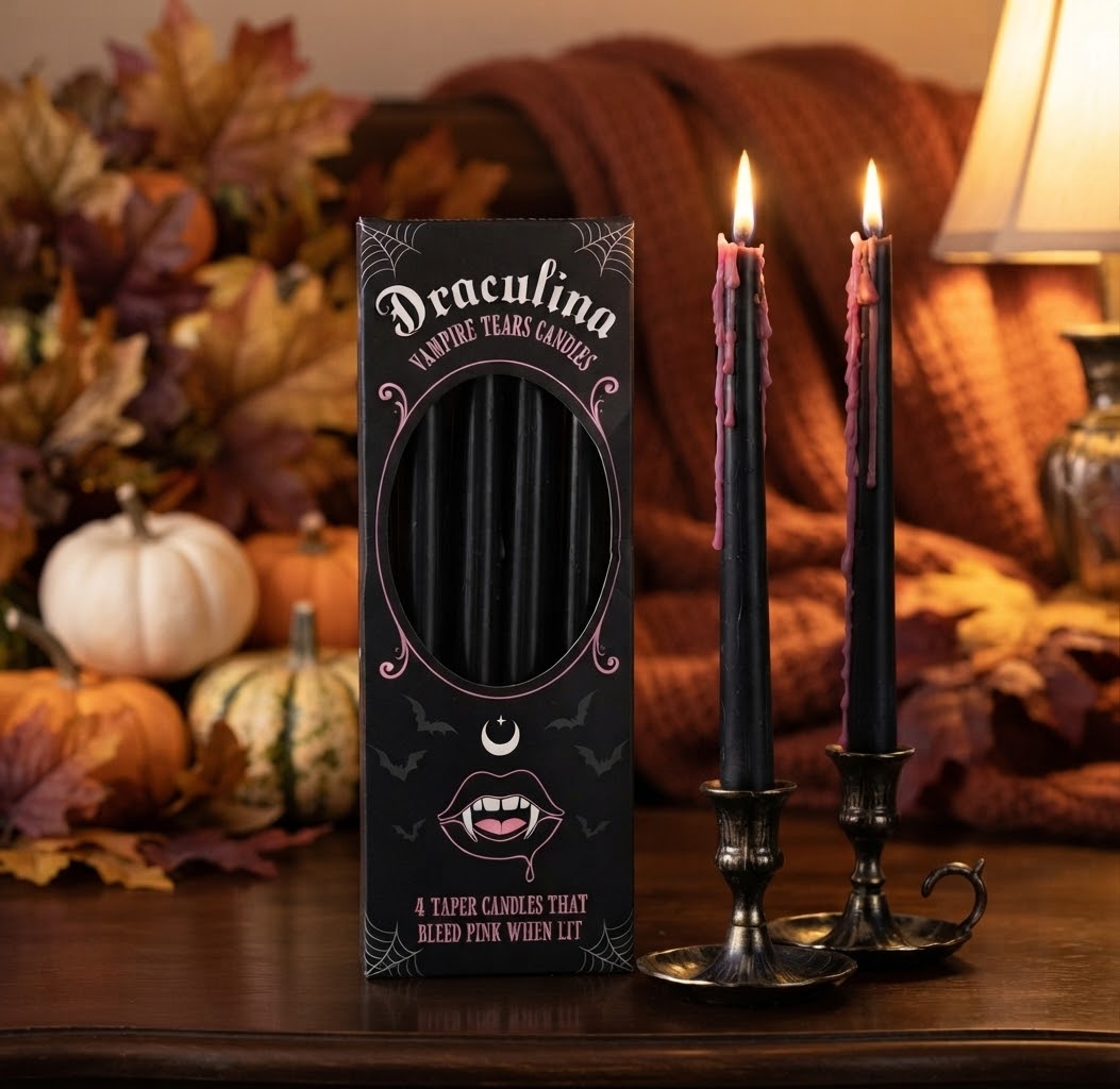 Een sfeervolle close-up foto van twee brandende Halloween kaarsen in een donkere, mysterieuze setting. De kaarsen hebben een griezelig effect waarbij roze was als tranen langs het zwarte kaarsvet naar beneden druipt.