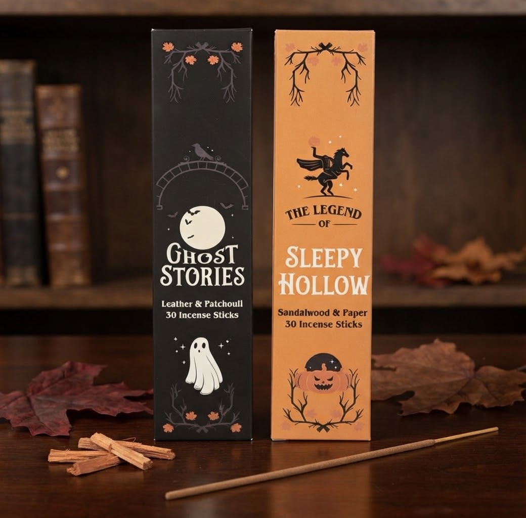 Twee rechtopstaande wierookverpakkingen, gethematiseerd rond 'Ghost Stories' en 'Sleepy Hollow', staan naast elkaar op een rustieke houten ondergrond. Op de voorgrond liggen losse wierookhoutsnippers en een enkel wierookstokje. De achtergrond is een zacht-vervagen boekenplank. De set bevat in totaal 60 wierookstokjes.