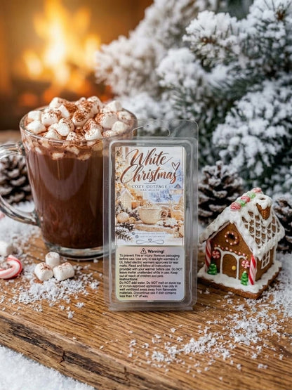 White Christmas waxmeltbar met het etiket naar voren, gefotografeerd bij een besneeuwde kerstboom met een peperkoekhuisje en chocolademelk, passend bij de frisse en winterse kerstsfeer.