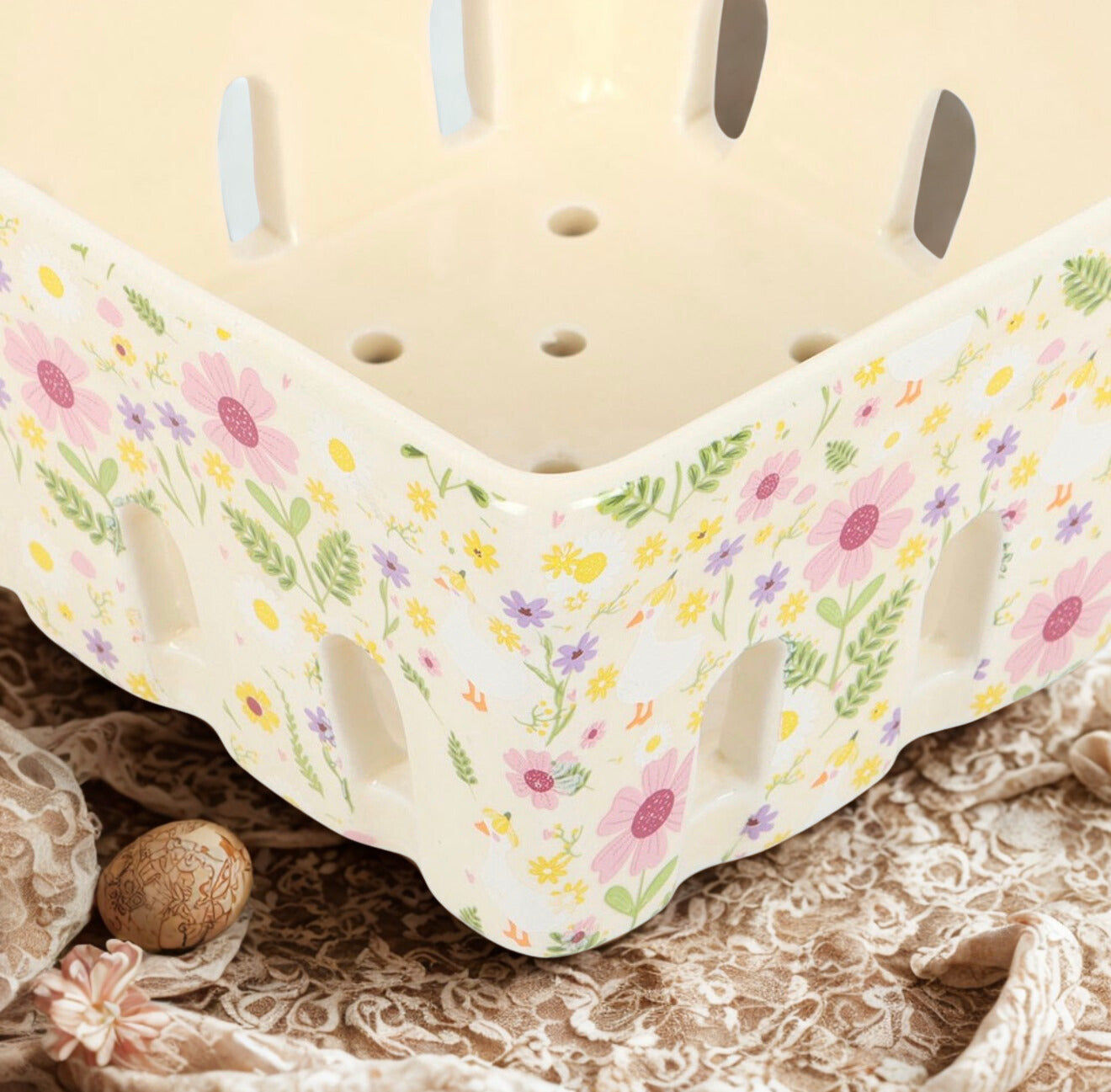 Close-up van de functionele gaatjes in het keramieken fruitzeefje met eendjes-design uit de Bliss & Bloom collectie.