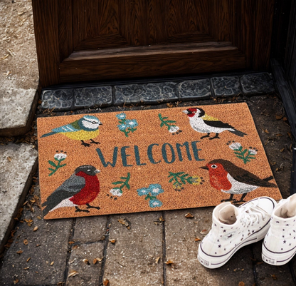 Sfeervolle kokos deurmat met vrolijke tuinvogels en 'Welcome' tekst bij een voordeur.