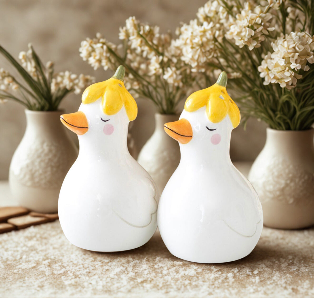 Peper en zoutstel eendjes met bloemenhoedjes als vrolijke paasdecoratie op tafel